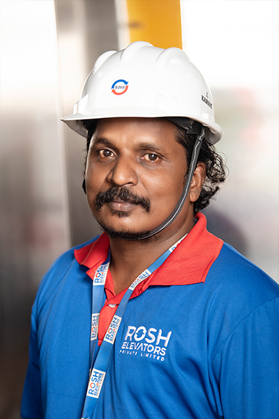 Man in a Rosh elevators uniform with a safety helmet .